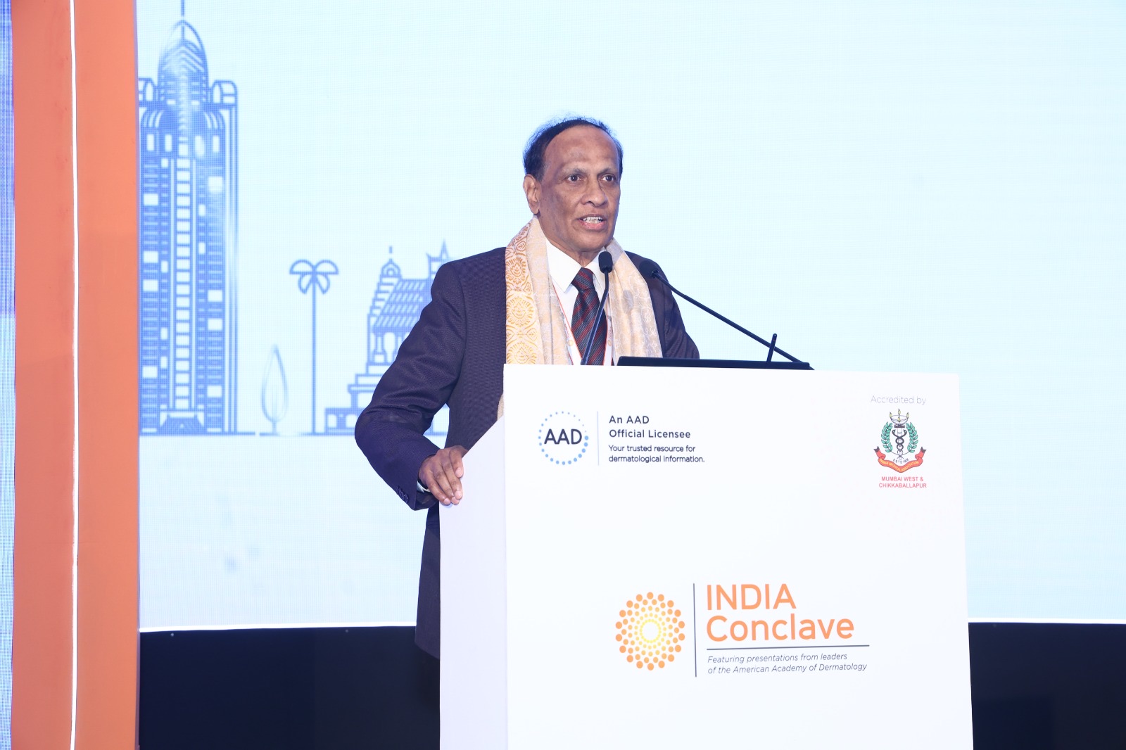 Dr. Satish speaking animatedly at a lectern during a conference presentation.